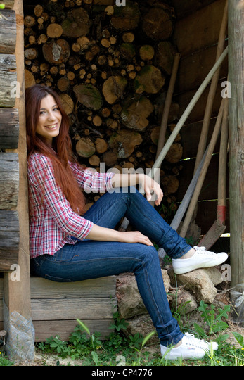 a-woman-sitting-in-a-wood-shed-in-a-garden-cp4776.jpg