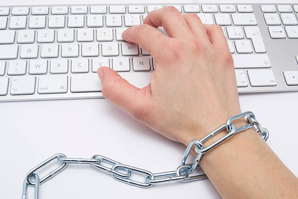womens-hand-chained-to-keyboard-picture-id140217744