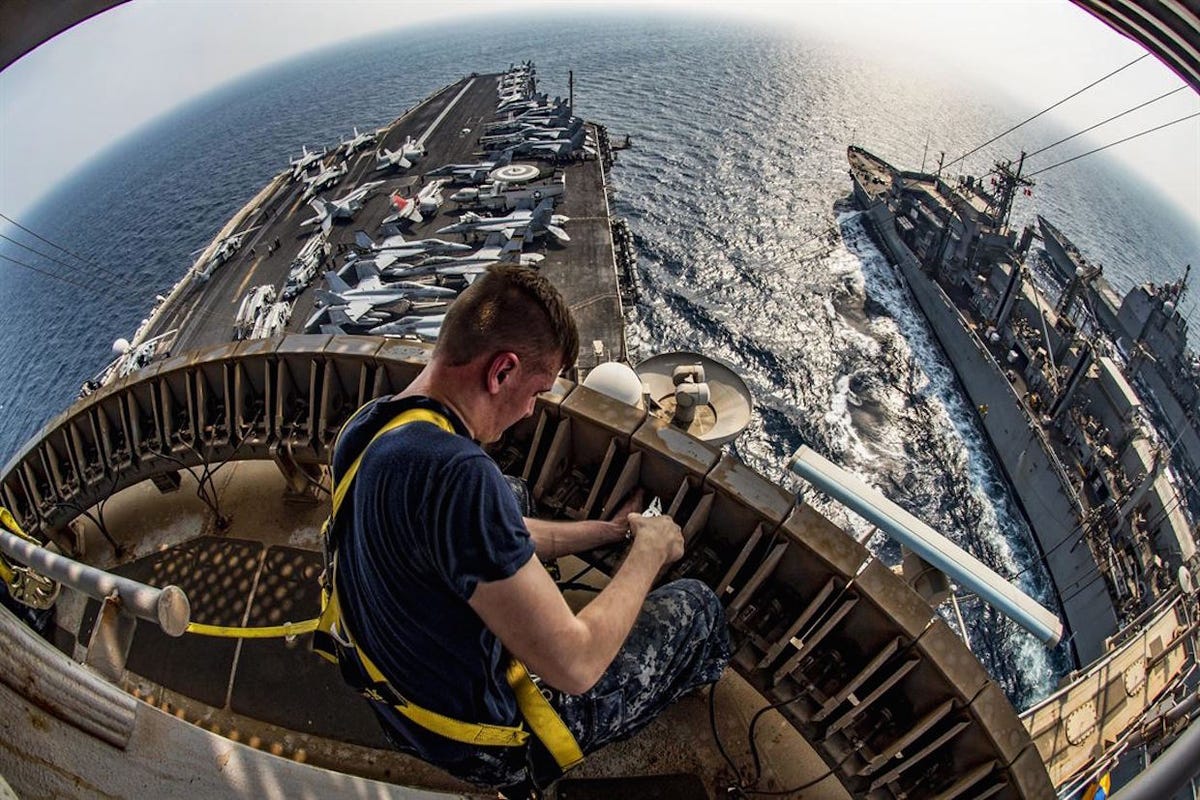 navy-petty-officer-3rd-class-brian-evans-repairs-an-antenna-system-during-a-replenishment-at-sea-involving-the-aircraft-carrier-uss-dwight-d-eisenhower-the-guided-missile-cruiser-