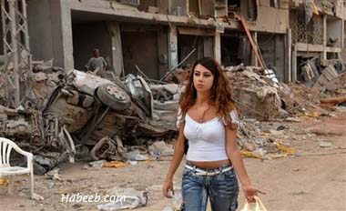 A.Lebanese.woman.walks.past.the.rubble.in.the.southern.suburb.of.Beirut.08-28-2006.jpg
