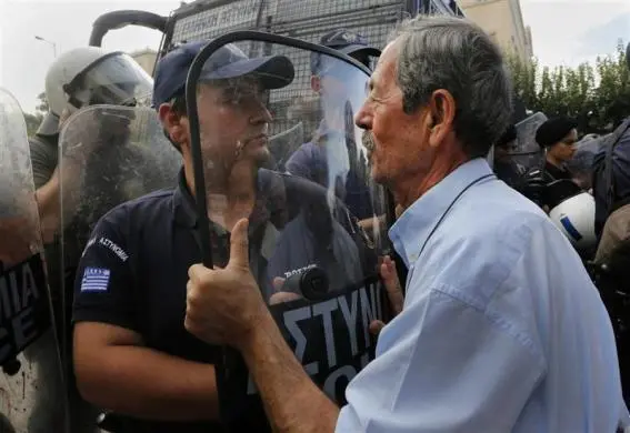 09102012-athens-greece-old-man-talks-to-riot-police.webp