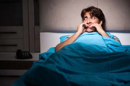 121246002-young-man-scared-in-his-bed-having-nightmares.webp