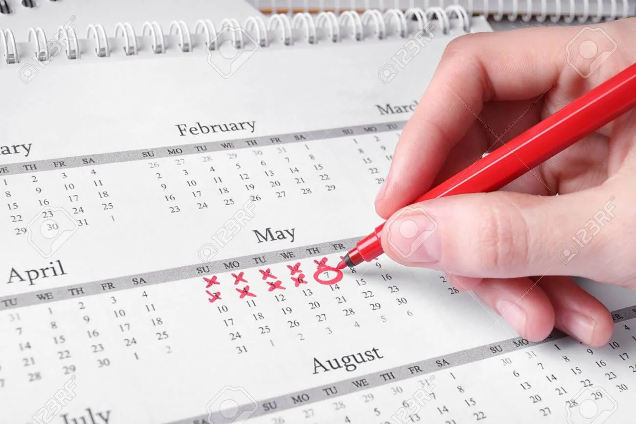 136192918-woman-marking-date-in-calendar-with-red-felt-pen-closeup.jpg