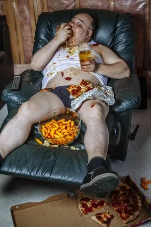 136666497-fat-couch-potato-eating-a-huge-hamburger-and-watching-television-harsh-lighting-fro...webp
