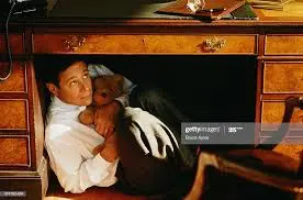 Executive Hiding Under Desk Clutching Teddy Bear High-Res Stock ...