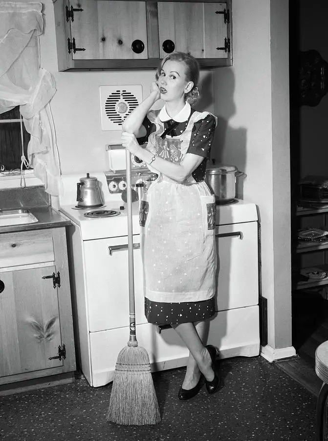 1950s-tired-housewife-in-apron-standing-vintage-images.webp