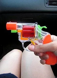 220px-Toy_Gun_being_held_in_car_with_legs_in_background.webp