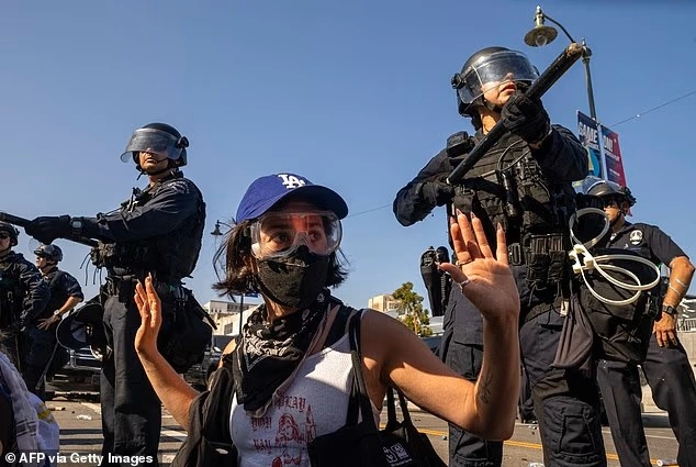 99180387-14794245-A_protester_raises_her_hands_as_she_is_surrounded_by_cops_follow-a-14_17494...webp
