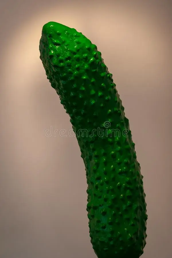artificial-green-big-cucumber-standing-upright-lighting-pink-background-blurred-154013692.webp