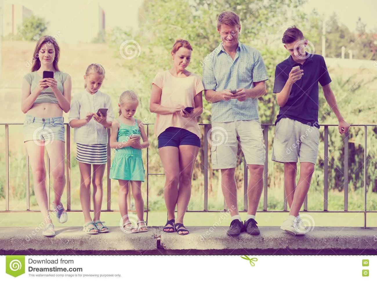 family-kids-playing-mobile-phones-four-town-summer-day-78340170.webp