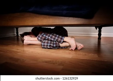 fearful-boy-hiding-under-bed-260nw-126132929.webp