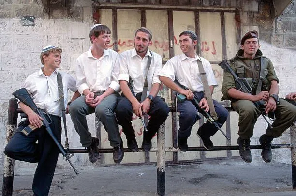 israelis-carry-guns-through-the-streets-of-hebron-shortly-before-the-picture-id635232173.webp