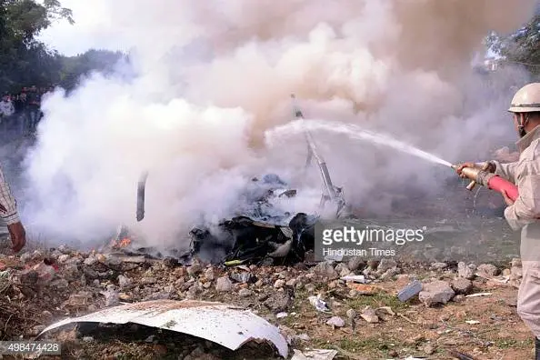rescue-personnel-douse-the-smoldering-wreckage-of-crashed-helicopter-picture-id498474428.webp