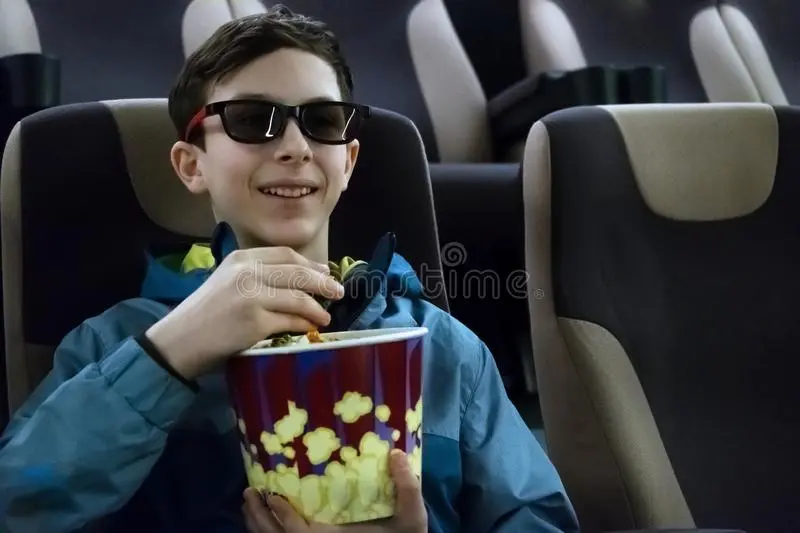 teenager-d-glasses-smiles-watching-comedy-movie-cute-european-guy-jacket-sits-cinema-chair-po...webp