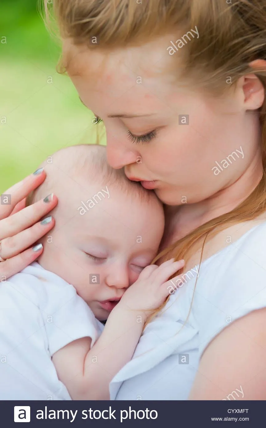usa-texas-mother-holding-her-sleeping-baby-boy-kissing-on-forehead-CYXMFT.webp