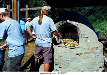 working-man-with-a-long-ponytail-baking-garlic-bread-in-outdoor-wood-eytcbt.jpg