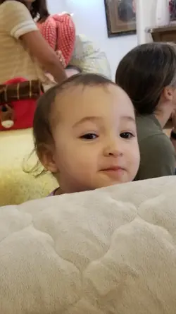 Quinn peaking over Grandma's chair 2021.webp