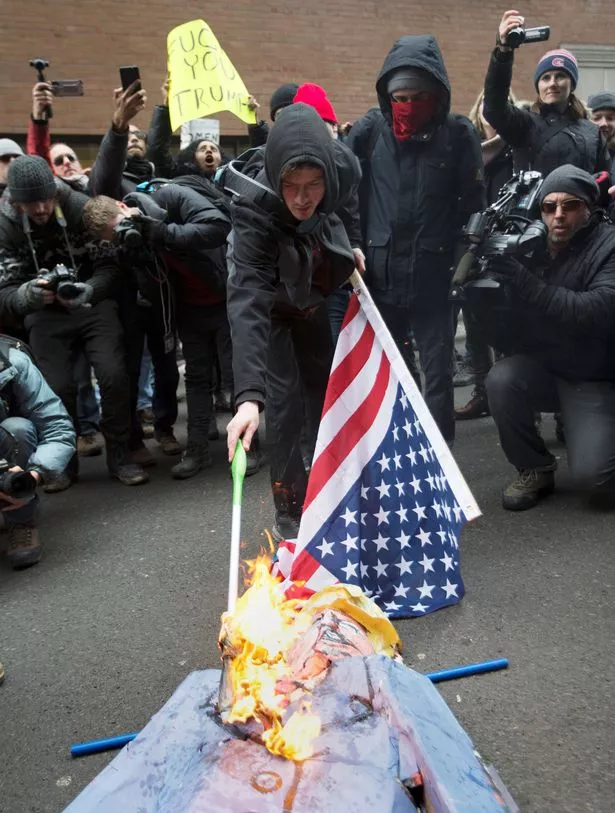 Protesters-burn-the-American-flag-and-an-effigy-of-US-President-Donald-Trump-in-front-of-the-US.jpg