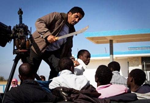 Libyan-rebel-threatens-captured-Blacks-with-machete-2011.jpg