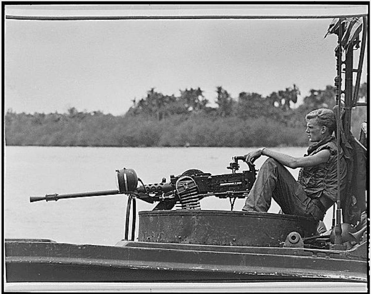 a-crewman-sits-behind-a-machine-gun-while-on-patrol-on-the-go-cong-river-fighting-in-dense-jungle-against-well-supplied-viet-cong-left-american-troops-frustrated-with-combat-conditions-it-was-after-this-war-that-post-traumatic-stress-disorder-was-officially-identified.jpg