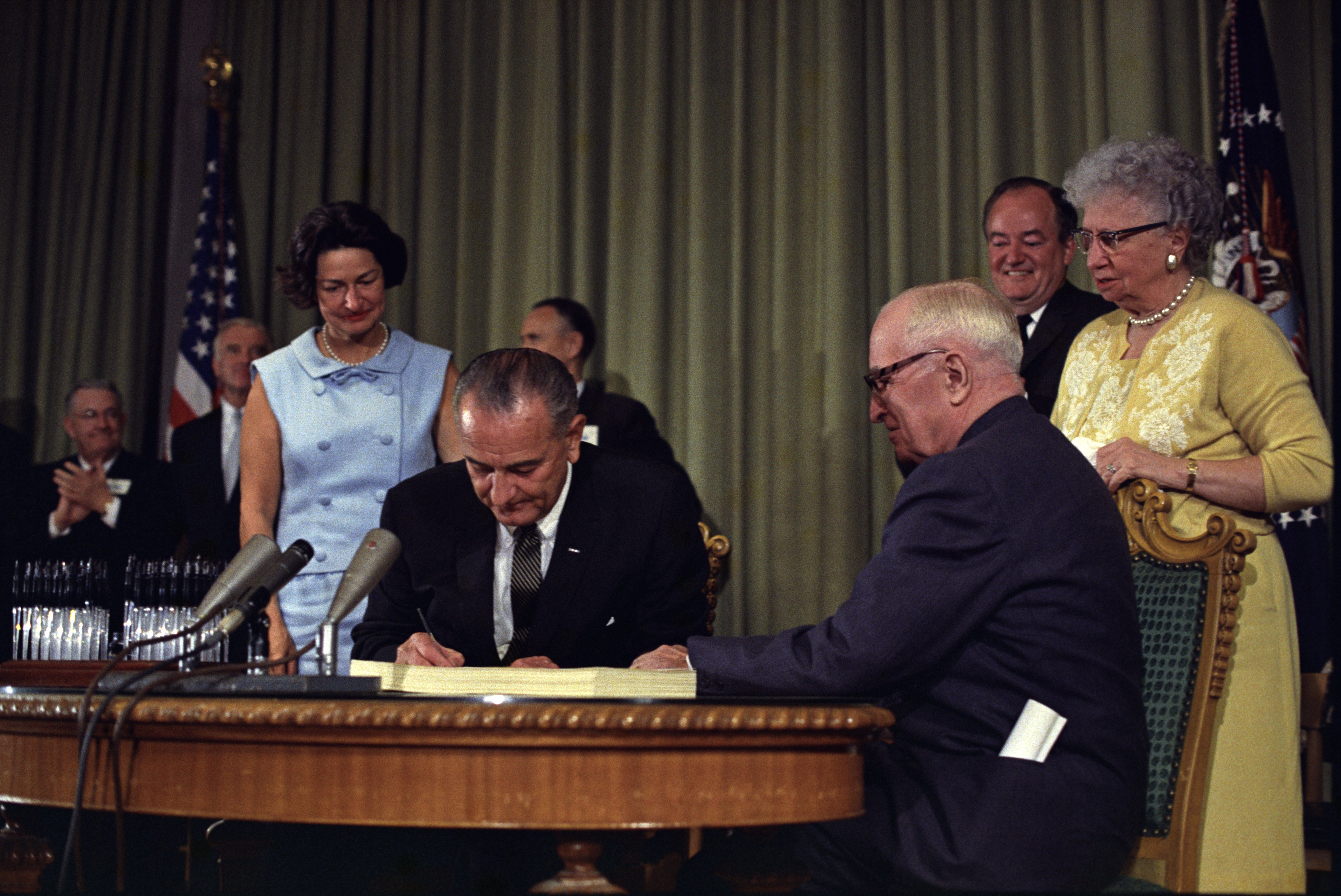 Lyndon_Johnson_signing_Medicare_bill,_with_Harry_Truman,_July_30,_1965.jpg