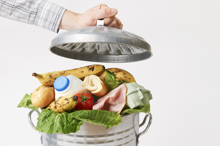 49373180-hand-putting-lid-on-garbage-can-full-of-waste-food.jpg